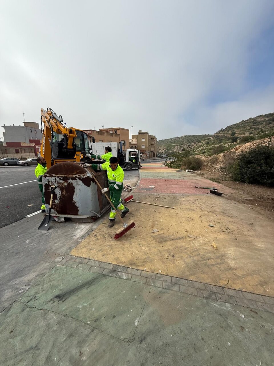 Operarios limpiando la calle Vía Láctea con maquinaria pesada