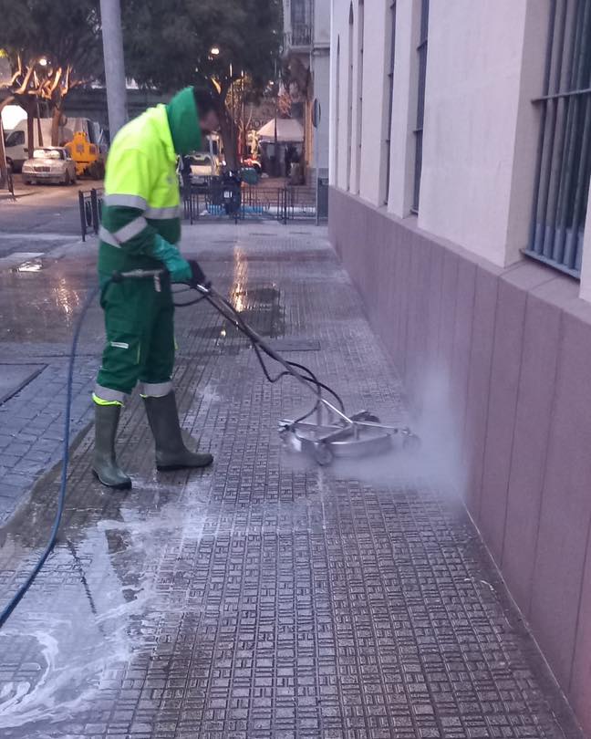 Trabajador limpiando la vía pública con maquinaria especializada