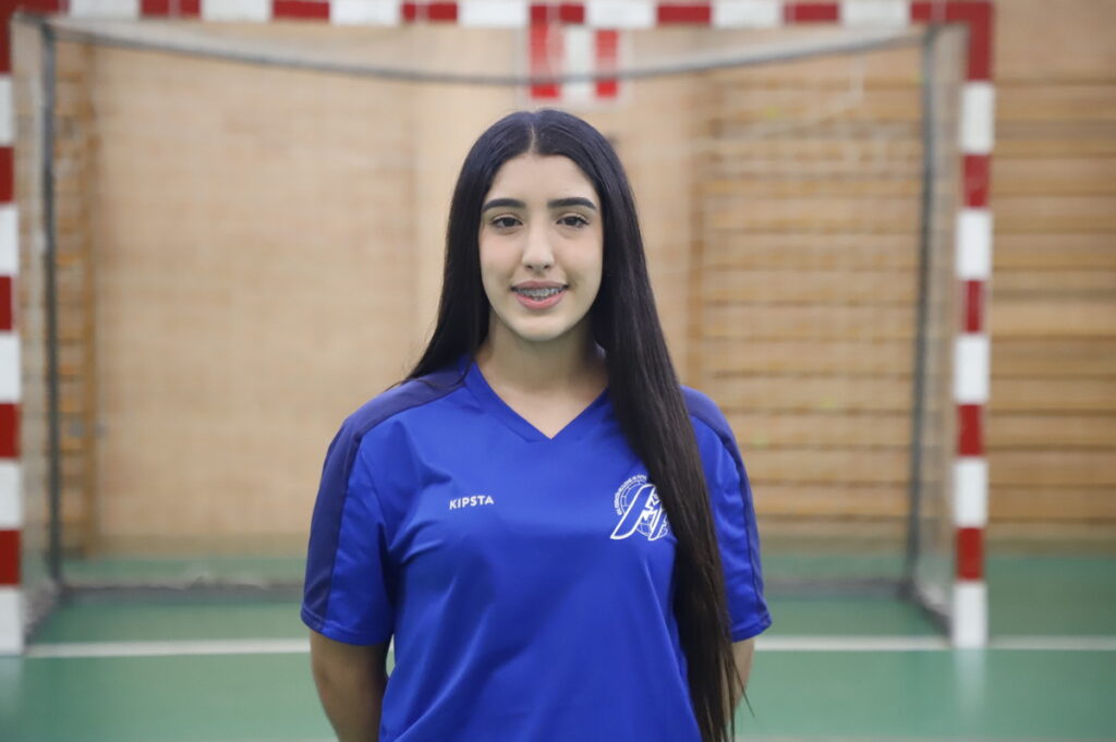 Jugadora de fútbol sala femenino en uniforme azul en un pabellón deportivo