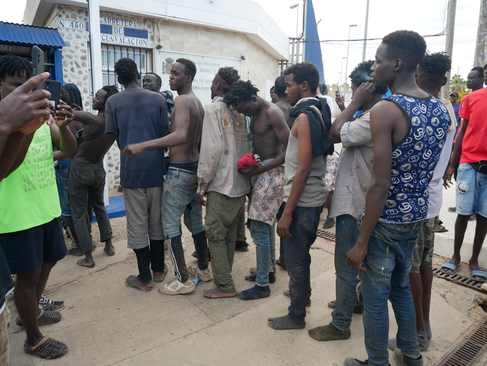 Grupo de migrantes en Melilla esperando atención en la calle