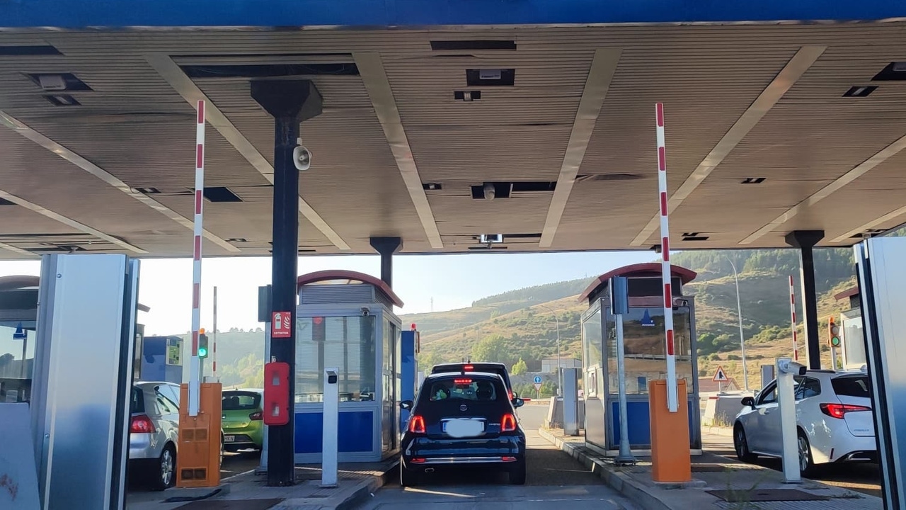 Peaje en carretera con vehículos esperando para pagar