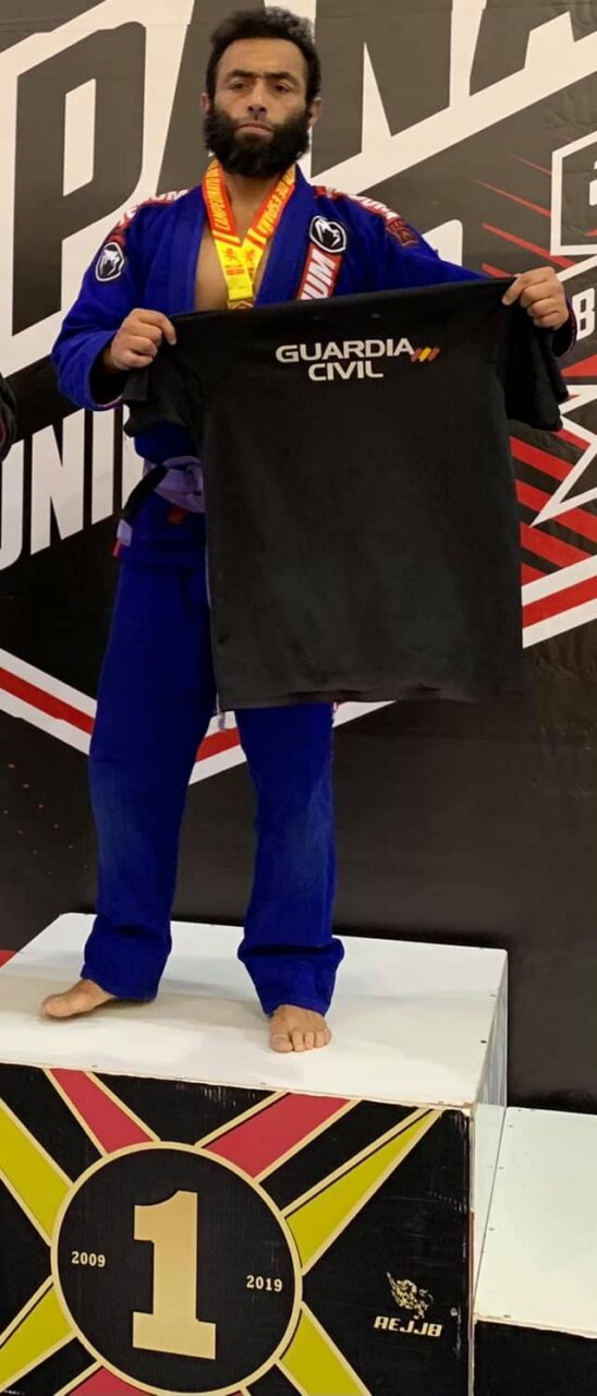 Luchador mostrando camiseta de Guardia Civil en podio