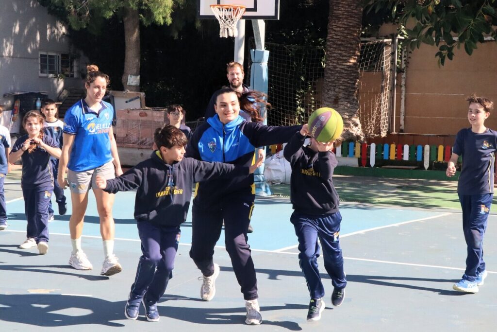 Niños jugando baloncesto en una cancha al aire libre