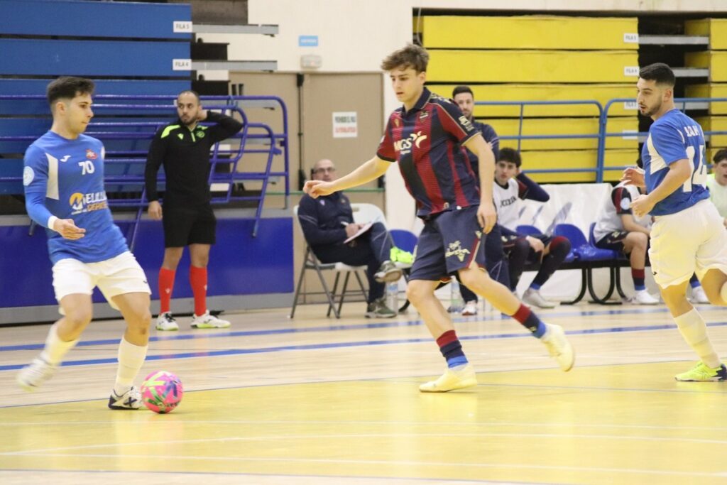 Jugadores de fútbol sala compitiendo en un partido en la cancha.
