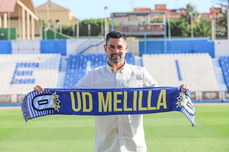 Rafael Ocaña sosteniendo una bufanda de la U.D. Melilla en el estadio