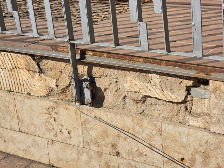 Detalle de una reja metálica y un muro de piedra en Melilla