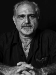 Retrato en blanco y negro de un hombre con barba y camisa negra