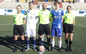 Jugadores y árbitros en el campo de fútbol con brazaletes verdes