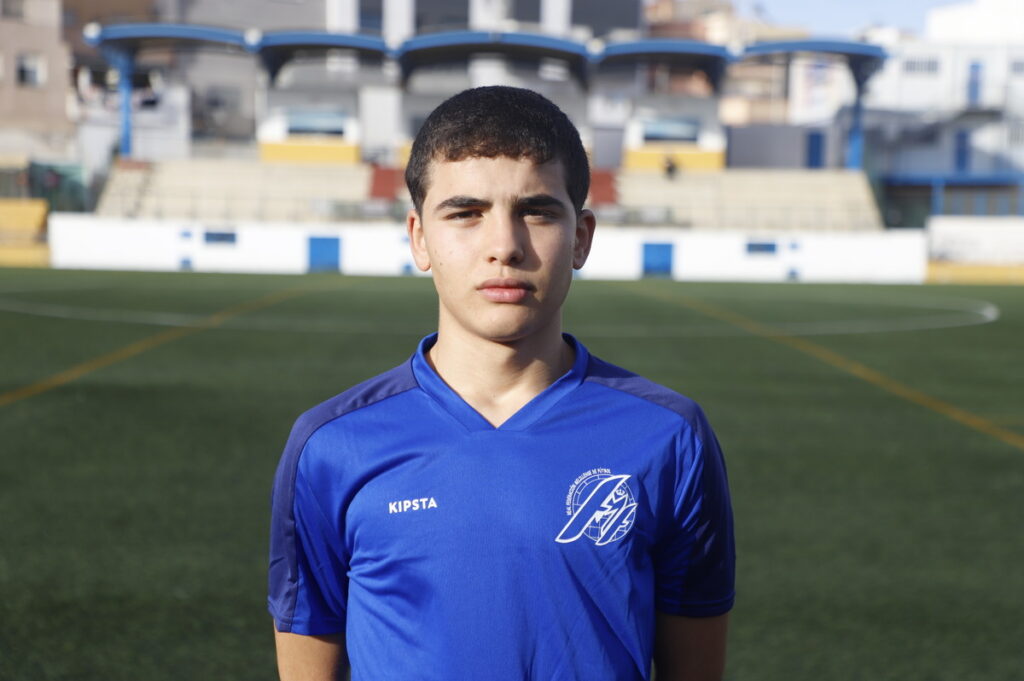 Joven futbolista melillense en campo de fútbol con uniforme azul