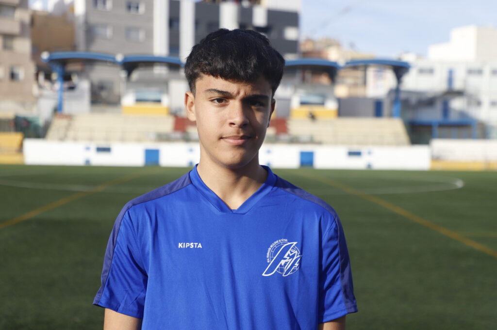 Joven futbolista melillense en uniforme de equipo en el campo