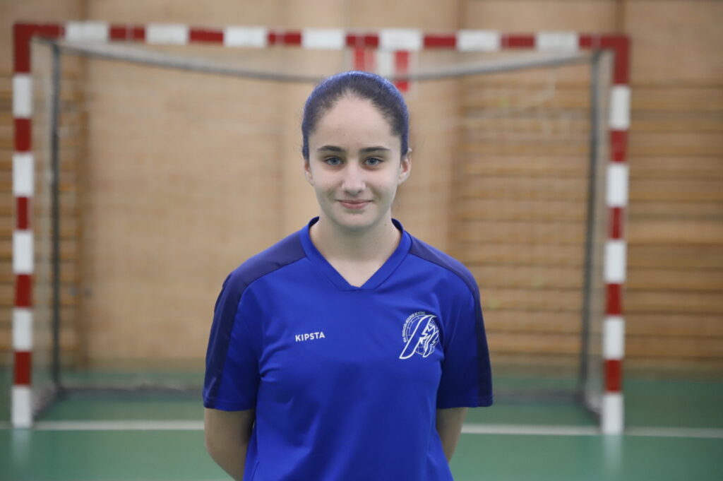 Jugadora de fútbol sala femenino en uniforme azul en un pabellón deportivo