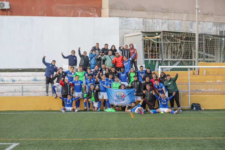 Jugadores y cuerpo técnico de la U.D. Melilla B celebrando en el campo