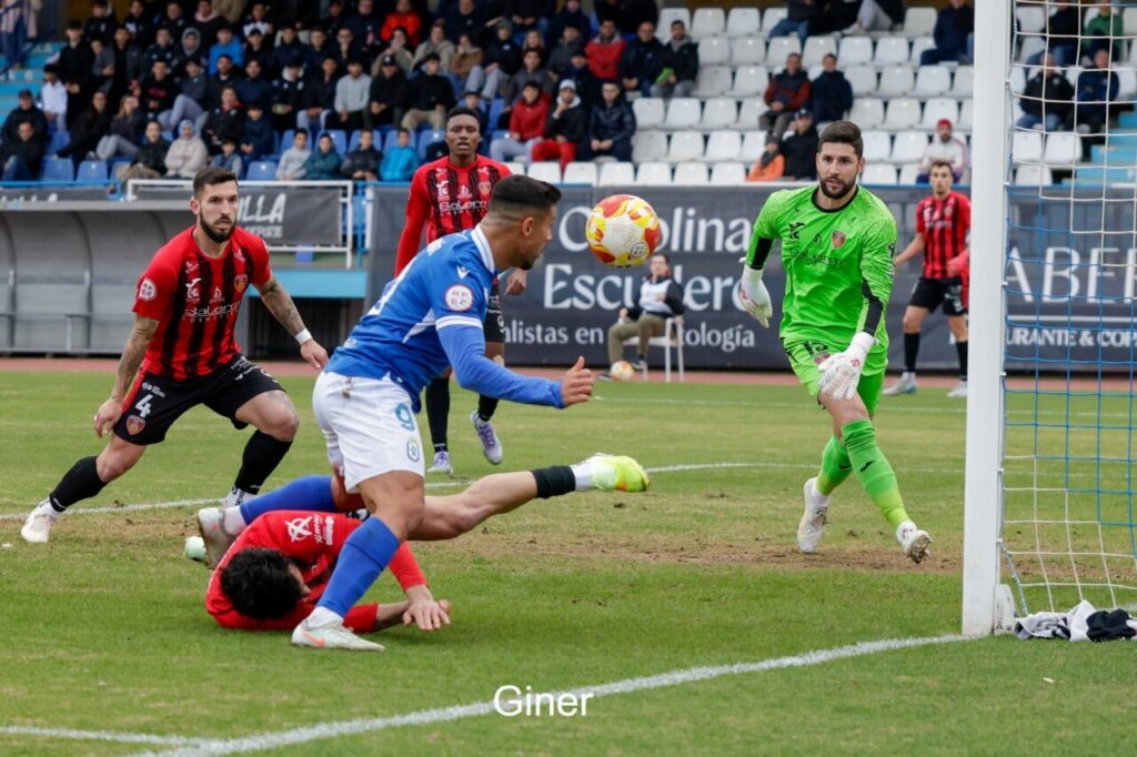 Jugadores de U.D. Melilla y Salerm Puente Genil en acción durante un partido de fútbol.