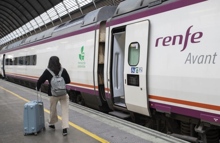 Pasajera con maleta abordando tren de Renfe en estación