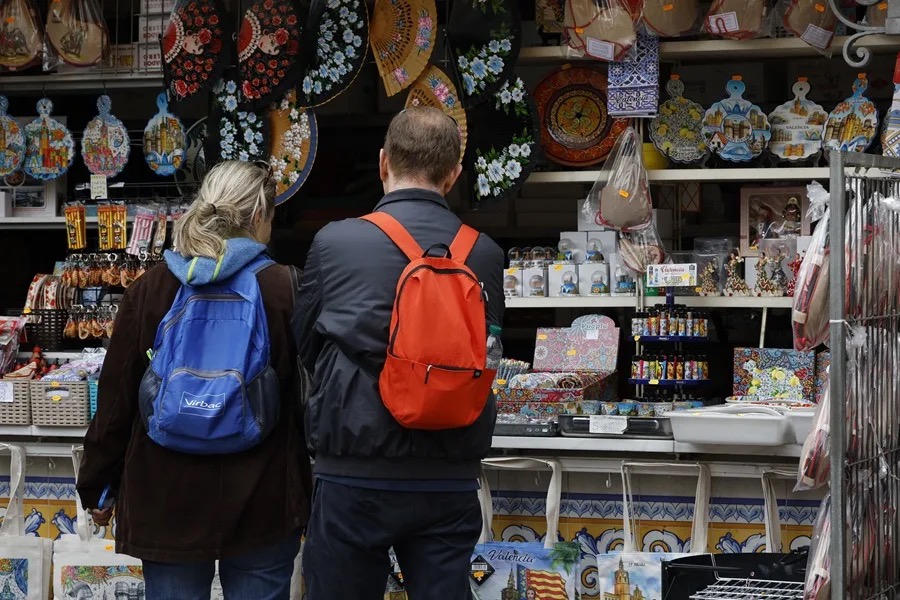 Pareja de viajeros sénior observando productos en un mercado