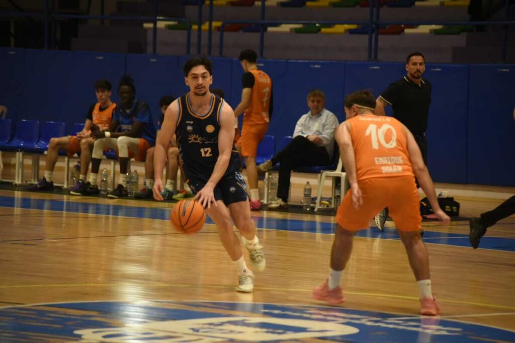 Jugador driblando con balón en partido de baloncesto