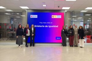 Grupo de personas en la visita al Ministerio de Igualdad con un fondo colorido