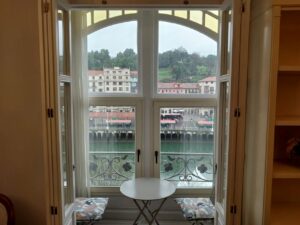 Ventana de una vivienda con vista al río y edificios cercanos.