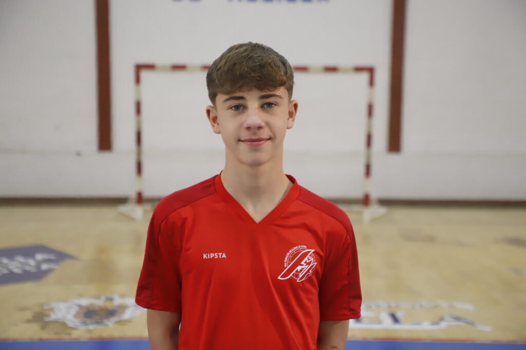Joven jugador de fútbol sala con camiseta roja en el pabellón
