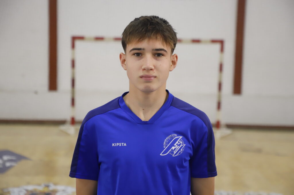 Joven jugador de fútbol sala en uniforme azul en un pabellón deportivo