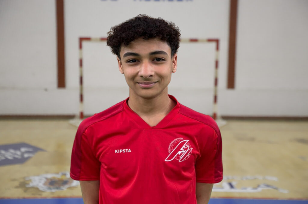 Joven jugador de fútbol sala con camiseta roja en un pabellón deportivo