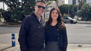 Dos personas sonrientes en una calle de Melilla con árboles al fondo