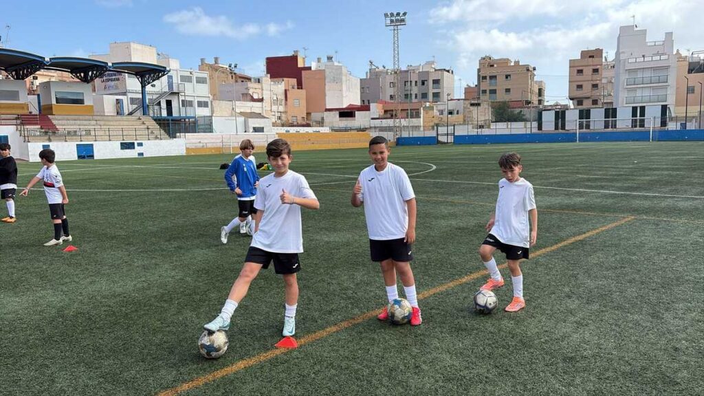 Niños entrenando en el campo de fútbol durante el campus de tecnificación