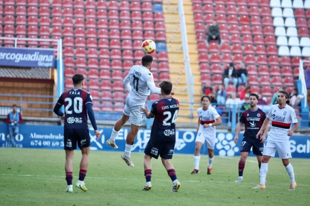 Jugadores de fútbol en un partido entre Melilla y Extremadura