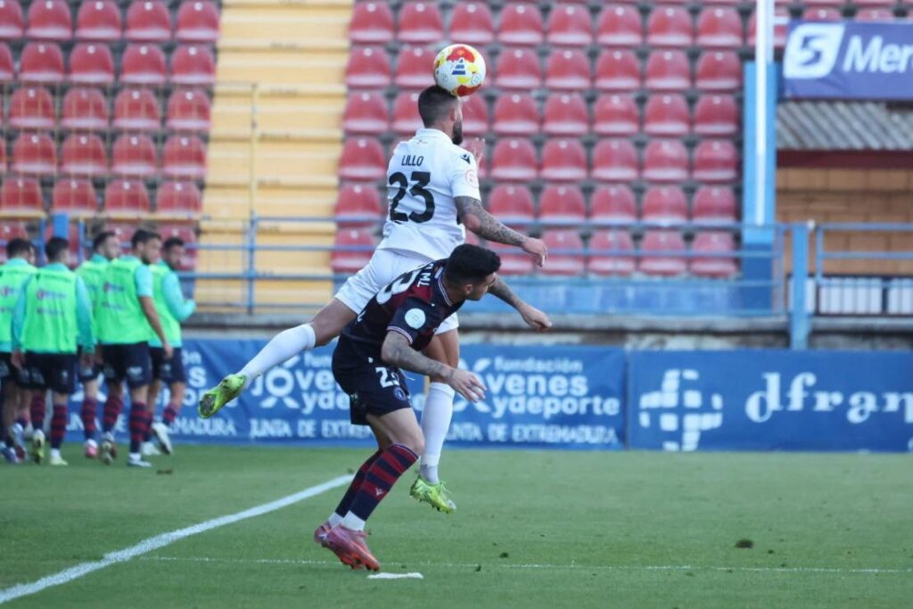Jugadores de fútbol en acción durante un partido entre Melilla y Extremadura
