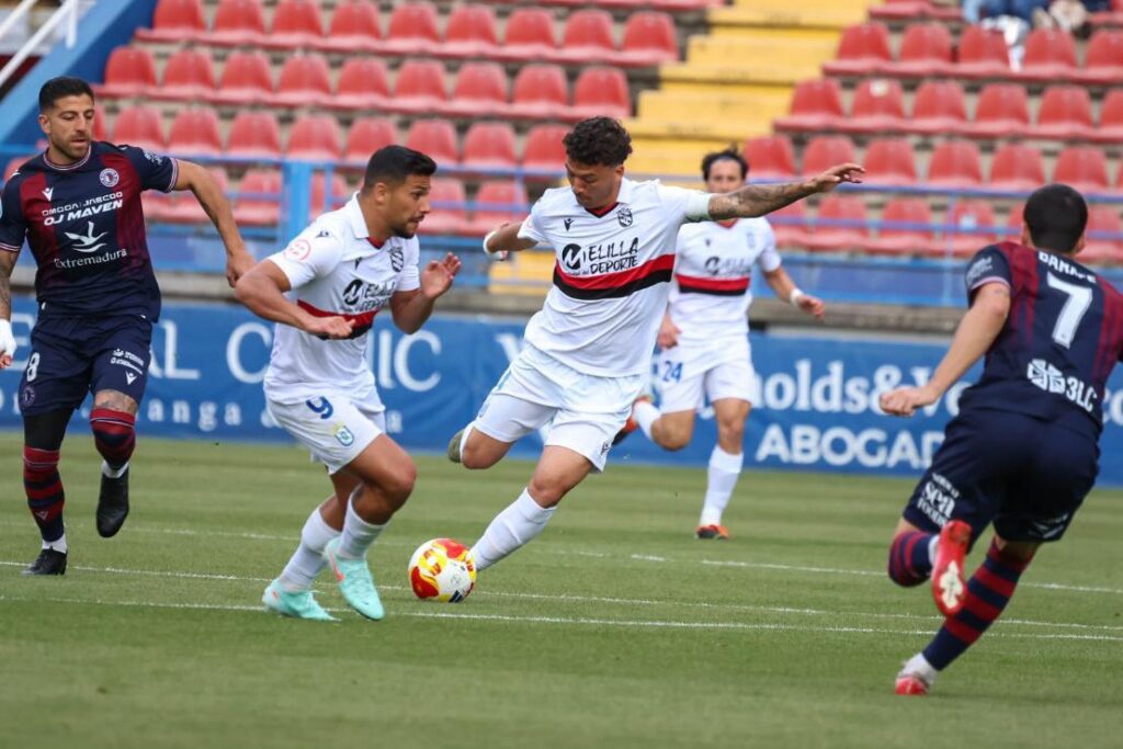 Jugadores de fútbol compiten en un partido entre Melilla y Extremadura