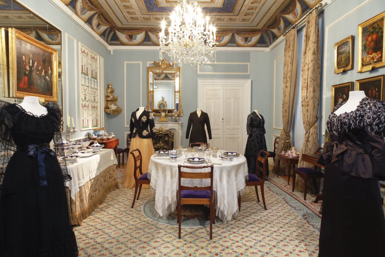 Sala de exposición con trajes de moda romántica y decoración elegante