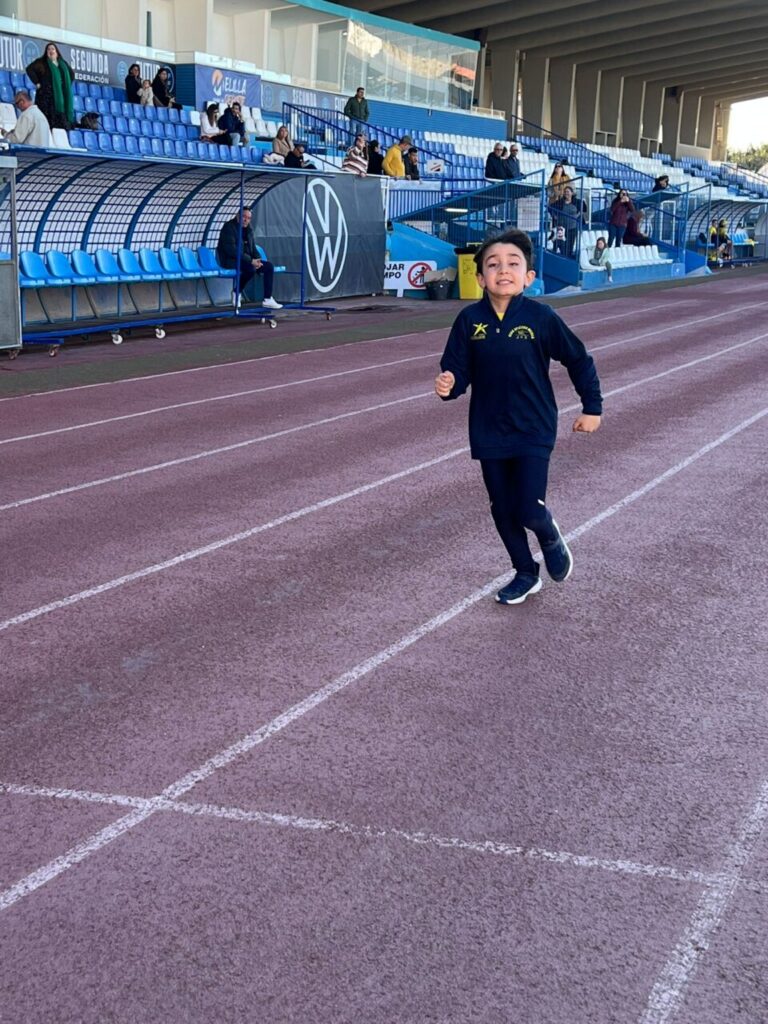 Niño corriendo en la pista durante la competición de fin de trimestre