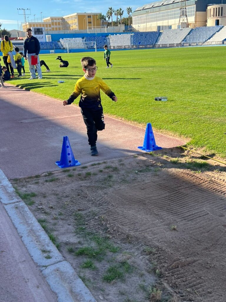 Niño corriendo en una competición de atletismo en el Estadio Municipal