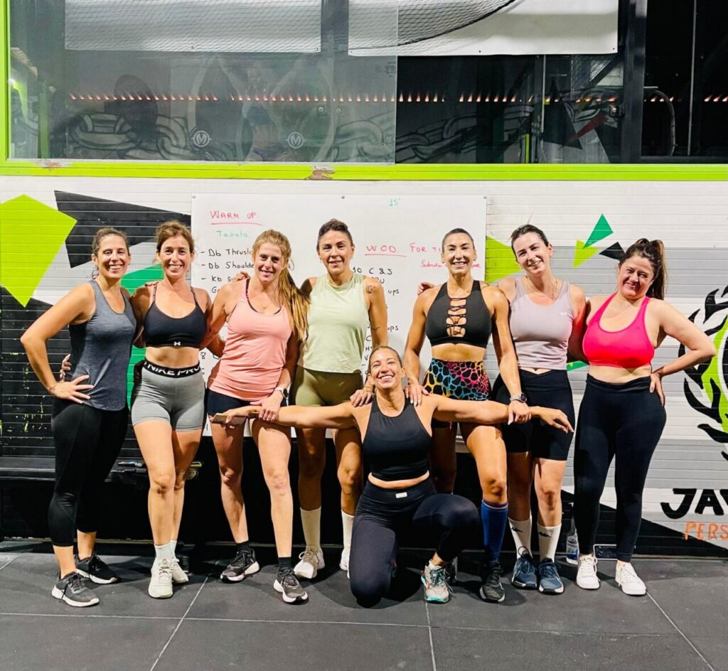 Grupo de mujeres posando en un gimnasio durante un evento de fitness