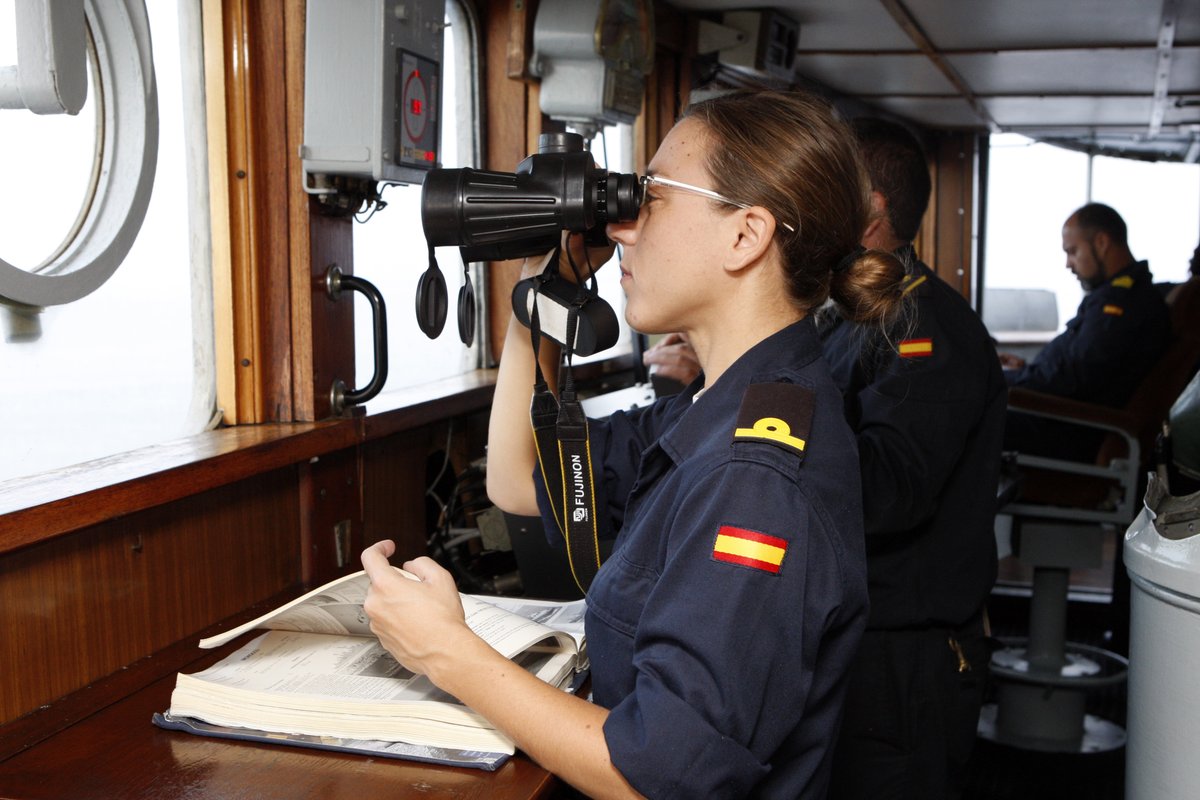 Militar observando con binoculares en un barco de la Armada española