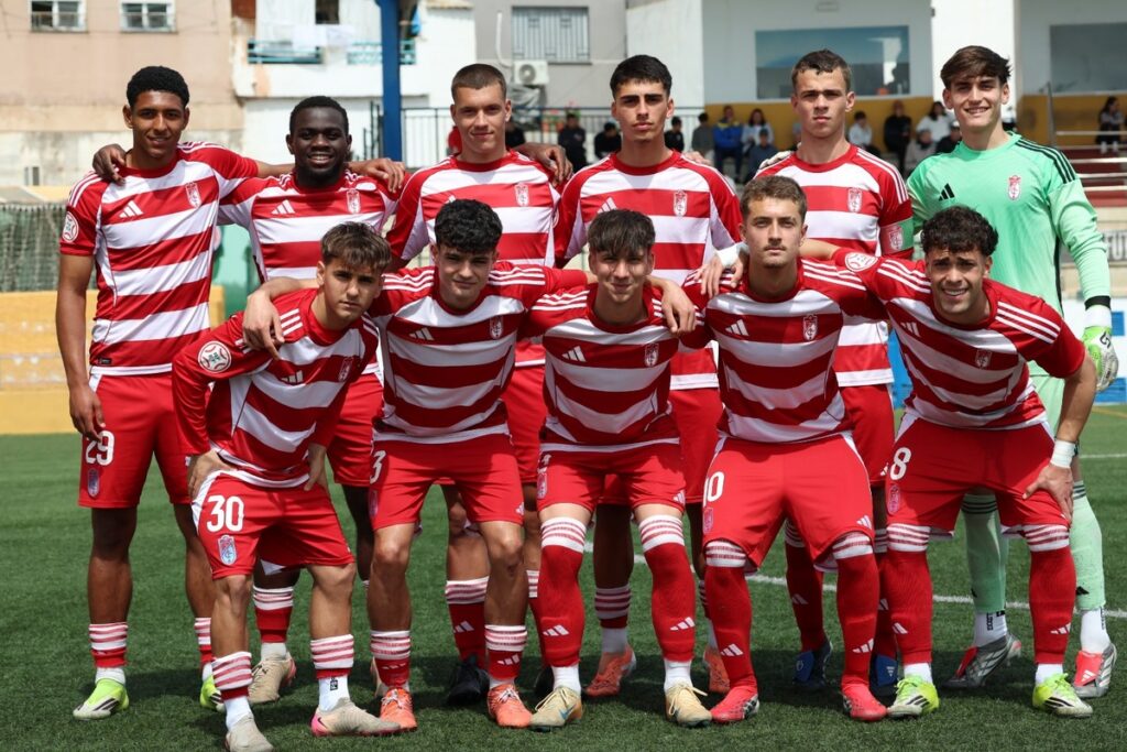 Equipo juvenil del Granada C.F. posando en el campo de fútbol