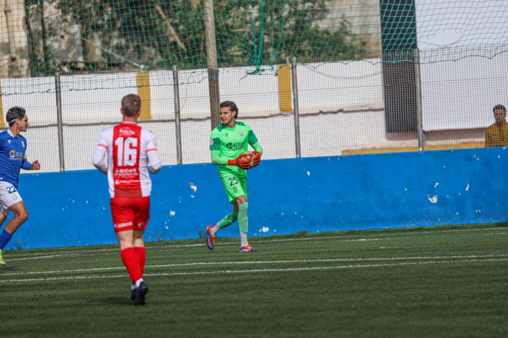 Portero del filial de la U.D. Melilla con balón en el campo