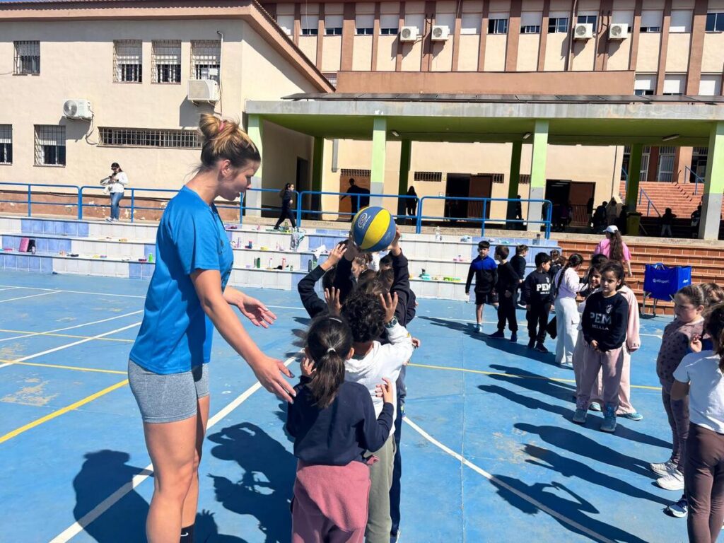 Jugadora de baloncesto interactuando con niños en el colegio