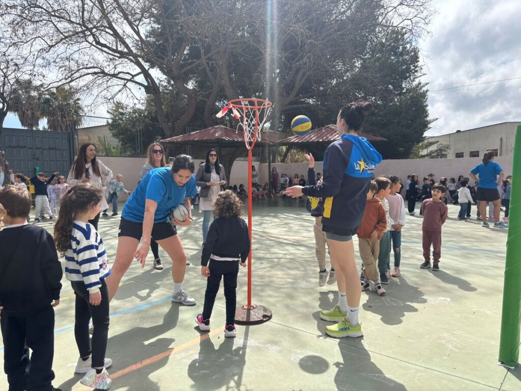 Jugadoras del MCD La Salle interactuando con niños en un colegio