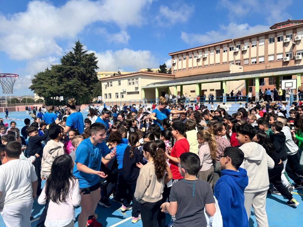 Jugadores de baloncesto interactuando con niños en el colegio Eduardo Morillas