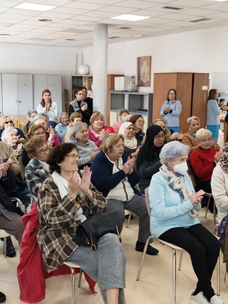 Asistentes a una charla sobre entrenamiento de fuerza para mayores en un centro social.