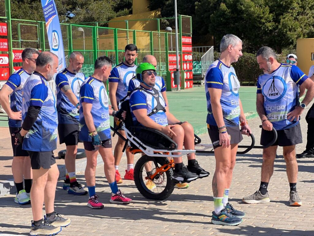 Grupo de personas con la silla Joëlette en un evento de senderismo inclusivo.