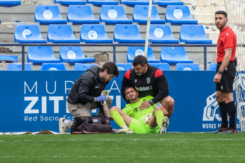 Jugador de la U.D. Melilla siendo atendido tras una lesión en el partido contra UCAM Murcia