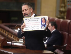 Santiago Abascal sostiene un cartel mientras critica a Pedro Sánchez en el Congreso.