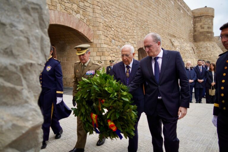 Ceremonia de homenaje en Melilla con autoridades llevando una corona de laurel