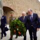 Ceremonia de homenaje en Melilla con autoridades llevando una corona de laurel