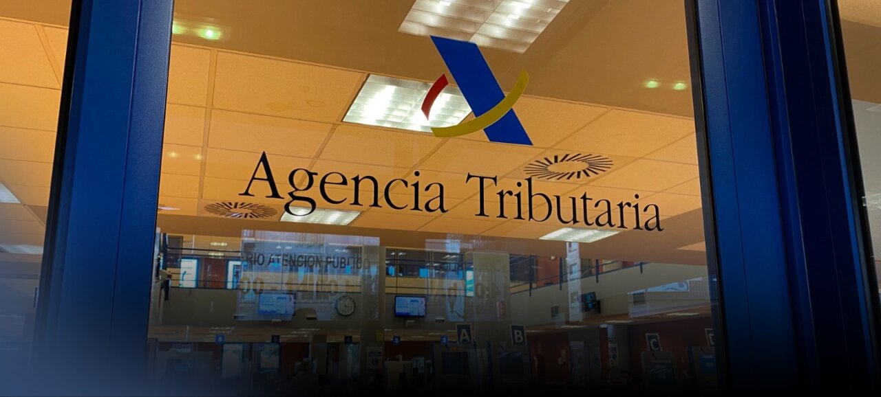 Entrada de la Agencia Tributaria con su logo visible en la puerta.