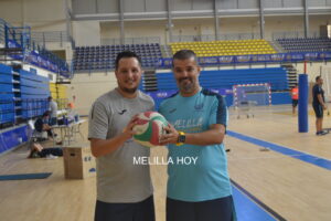 Alberto Rodríguez y un colaborador sosteniendo un balón de voleibol en el gimnasio