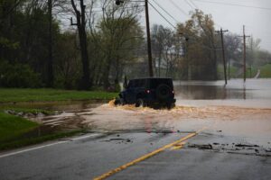 Vehículo atravesando una carretera inundada durante una emergencia climática