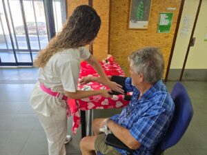 Una enfermera toma la presión a un paciente mayor en un consultorio